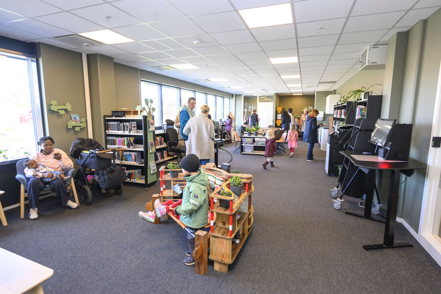 Mennesker som står og sitter hver for seg i et bibliotek