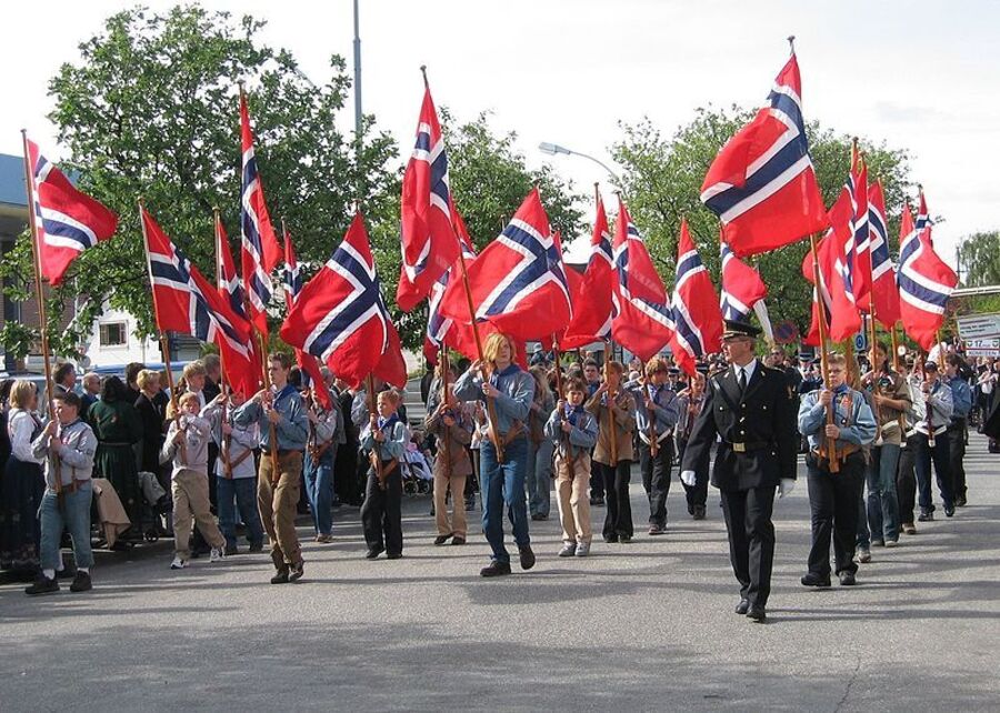 Speidere marsjerer med flagg 17. mai