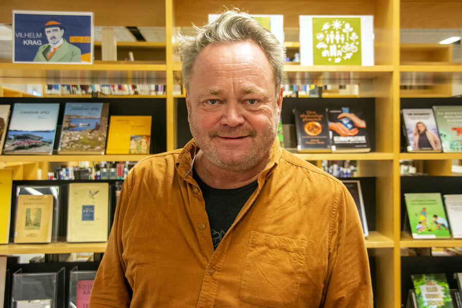 Portrett Fredrik Græsvik foran bokhyller