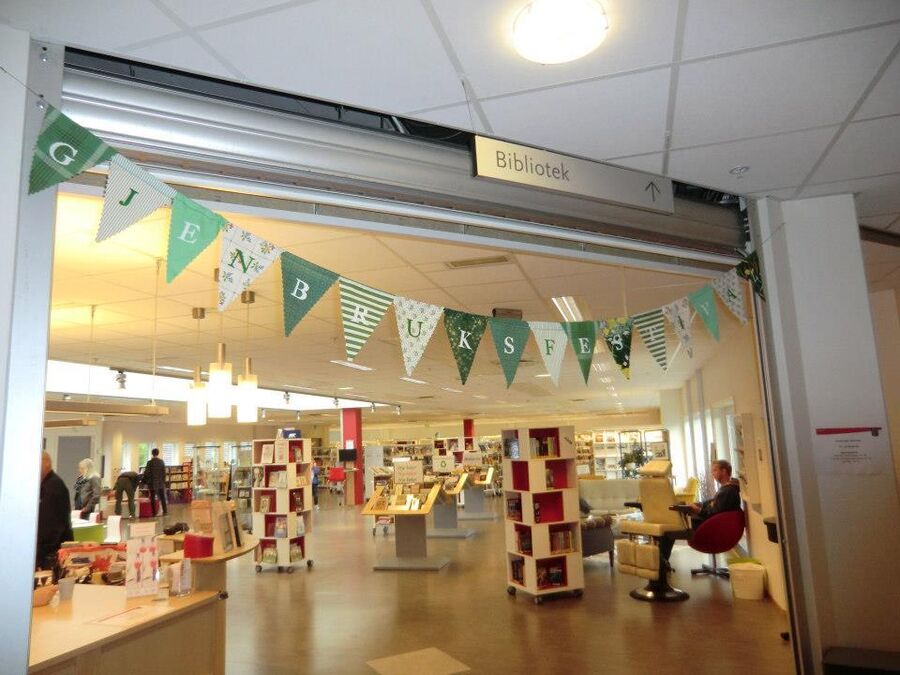 Inngangen til Vågsbygd bibliotek, med banner til gjenbruksfestivalen